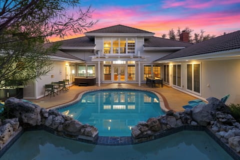 Resort-style pool and covered patio at sunset.