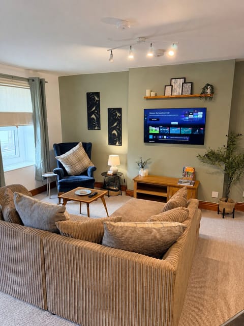 Cozy lounge with plush sectional, smart TV, and warm modern styling