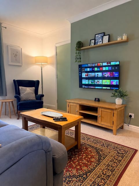 Cozy lounge with smart TV, stylish seating, and warm natural touches