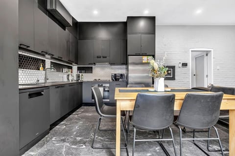 Matte black cabinetry kitchen with hexagon tile detail.