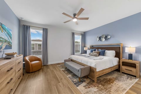Unwind in this serene bedroom featuring a plush king bed, soft blue accents, and modern decor for a relaxing night's sleep.