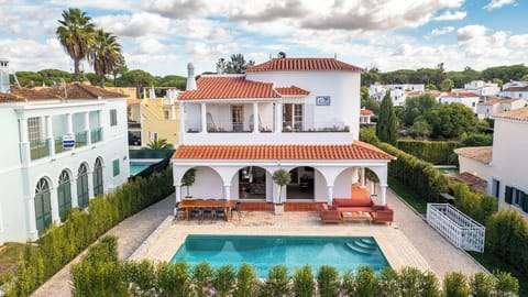 A renovated Portugese villa with a pool and lounge area.