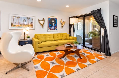 Bold mustard sofa with vibrant orange retro rug design