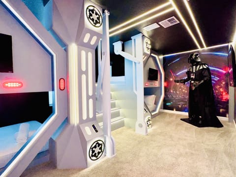 Another view of the immersive space-themed bedroom and custom sleeping area.