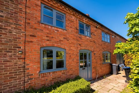 The brick barn conversion opens onto a paved courtyard at the rear.