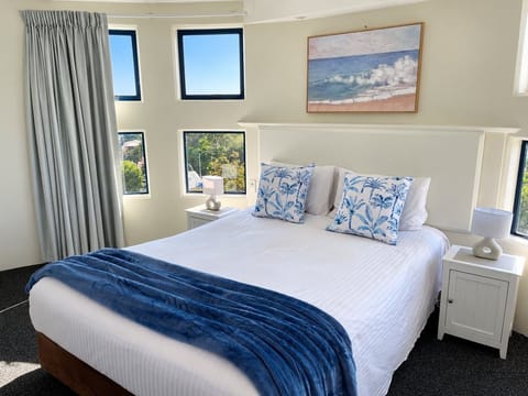 Wake up in your peaceful coastal bedroom, with a comfortable queen bed and windows framing the Golden Beach outlook.