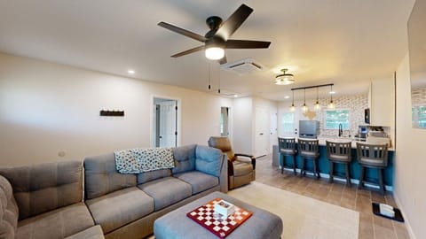 Living room with sectional sofa, reclining chair, games, and smart TV