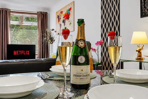 Stylish dining space with bubbly, Netflix, and a warm modern lounge