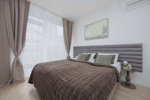 Elegant bedroom zone featuring stylish green accent cushions, a crisp white wardrobe, and soft lighting fixtures.
