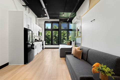 🌳 Warm lounge framed by treetop views—soft seating and natural light set a relaxed tone from the moment you walk in.