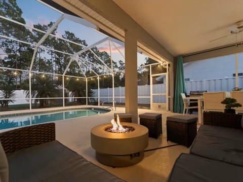 Screened private pool lanai with cozy fire table and outdoor lounge