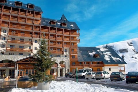 Fresh snow surrounds the stone-based building with wooden balconies.