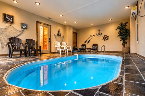 Private indoor plunge pool with cozy seating and charming nautical style