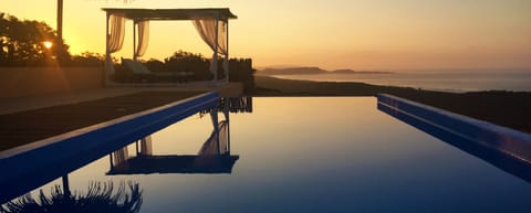 Outdoor pool, an infinity pool, open 6:00 AM to 9:00 PM, pool umbrellas