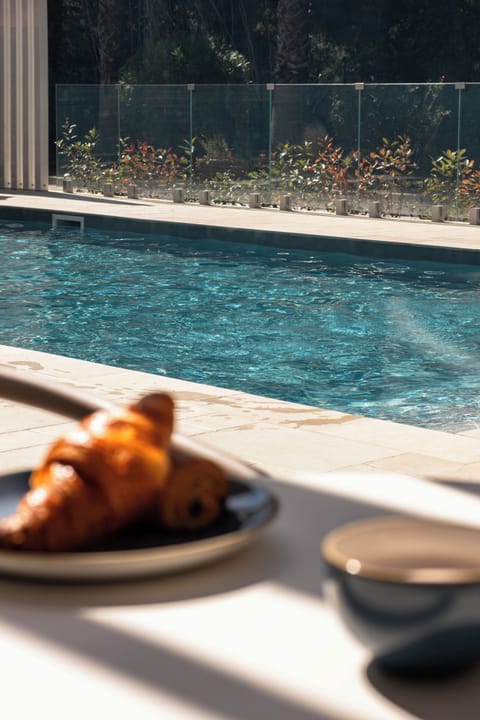 Seasonal outdoor pool, open 9:00 AM to 8:00 PM, pool umbrellas