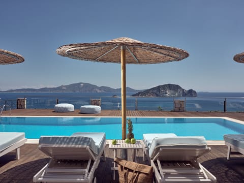 Outdoor pool, an infinity pool, pool umbrellas, sun loungers