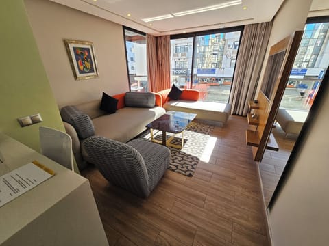 Deluxe Suite | Living area | 42-inch flat-screen TV with satellite channels, TV