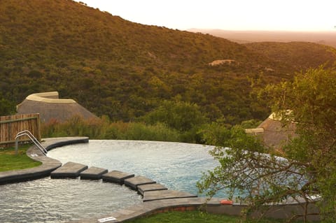 Outdoor pool, an infinity pool, pool umbrellas, sun loungers