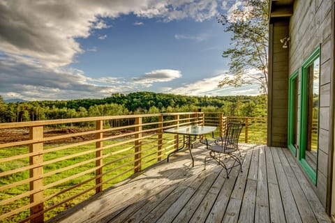 Deck overlooking large open field.