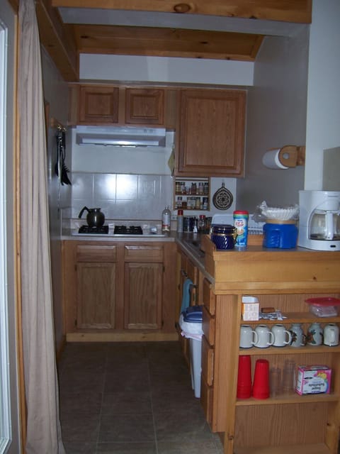 Galley kitchen fully equipped with utensils, basic cooking supplies.