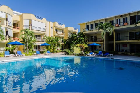 Big crystal clear swimming pool with sunbeds and beach umbrellas.