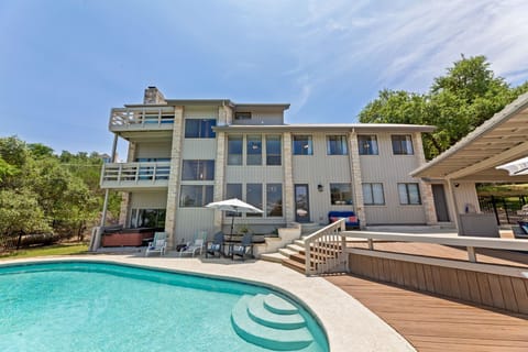 Rear view with large pool and covered patio area. Hot tub, pool basket ball hoop