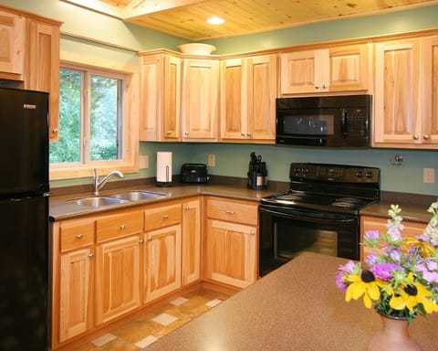 Fully equipped kitchen with solid surface countertops and ceramic tile floors.