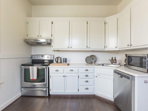 Pantry is stocked with spices, oils and condiments. Pro cutlery, stemware + 