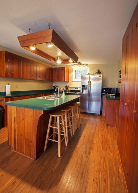 Kitchen with new appliances and 4 bar stools at the island