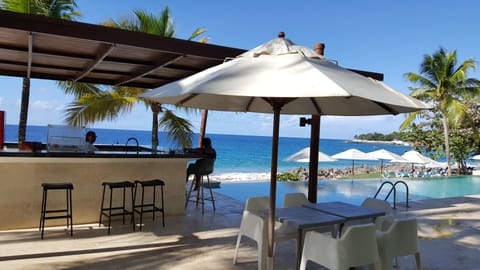 Crystal clear Infinity pool with bar and sunbeds overlooking our private beach.