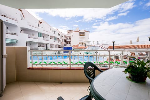 balcony with table chairs overlooking pool