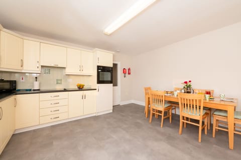 Spacious Kitchen: glass hob, single oven, microwave, dishwasher, dining table.