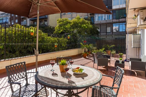 The spacious and sunny terrace looks out onto an interior urban garden
