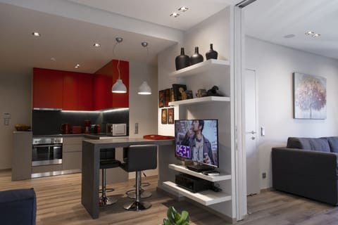 The living room with the 43 inch TV and the kitchen on the back