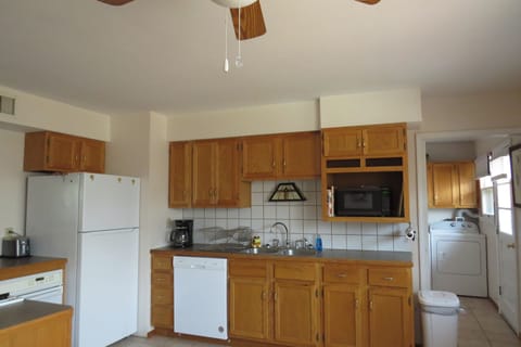 Kitchen sink, dishwasher, coffee pot, coffee, sugar, tea in cabinet. microwave.