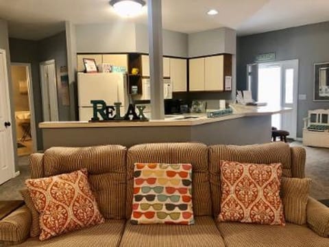 Living area in open concept floor plan with kitchen area behind. updated 11/25.