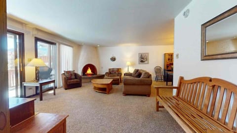Settle into this inviting living space where warm wood tones and a cozy fireplace create the perfect mountain retreat. The open layout gives you room to spread out and relax after your adventures.