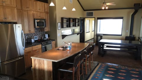 Open kitchen great room design with 180 degrees of picture windows