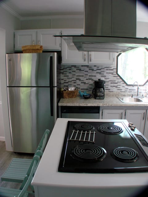 View of new stove, range hood, refrigerator and sink with lake view. 