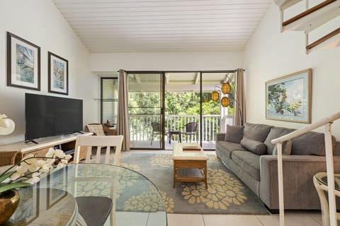 Sunny living room opening to a leafy patio for easy lounging & breezy vibes.