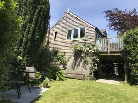 Looking up at the Boathouse from the garden, with small patio area outside