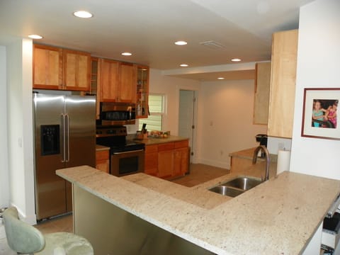 Roomy kitchen with new granite and stainless fixtures.