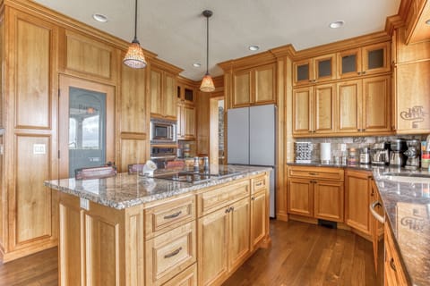 The large kitchen has lots of cabinets and counter space, loaded with supplies