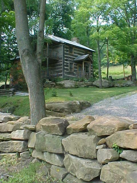 Stone wall and log house.
