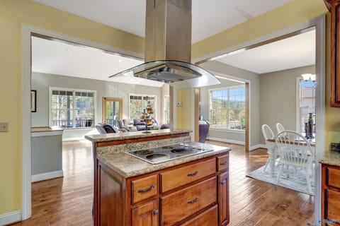 Island in the kitchen has wall oven and stove in the island