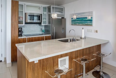 Fully stocked modern kitchen with cooktop, convection oven, dishwasher & fridge