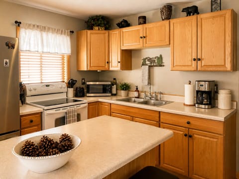 Your fully equipped kitchen awaits with warm wood cabinetry, full-sized appliances, and ample counter space for preparing memorable meals during your stay.