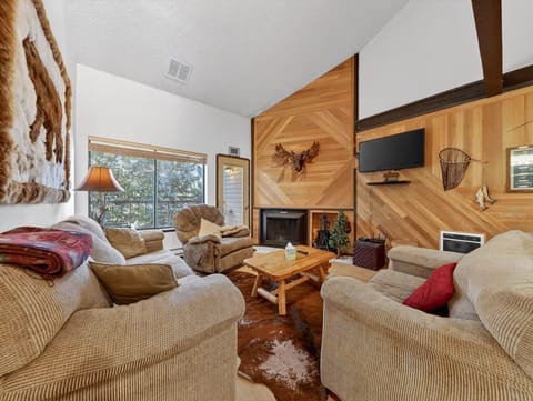 Cozy up by your private fireplace in this warm living room, where rustic charm meets comfort with plush seating and mountain-inspired décor.