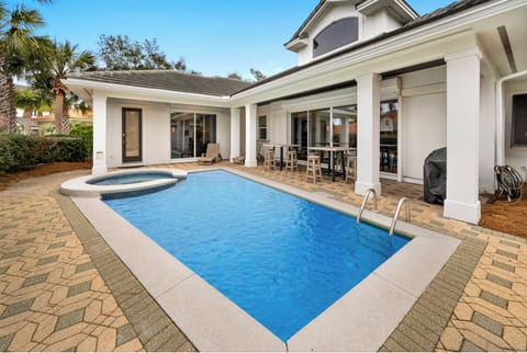 Your private pool awaits with sparkling blue water and a relaxing spa, surrounded by elegant covered dining under swaying palms.