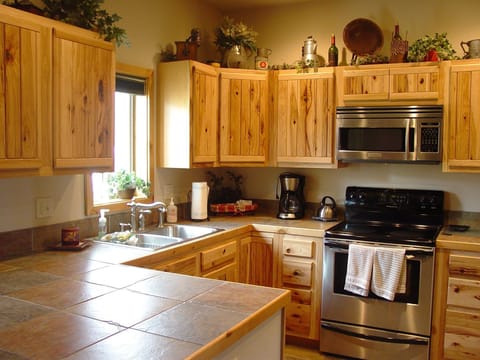Hickory cabinets in well stocked kitchen